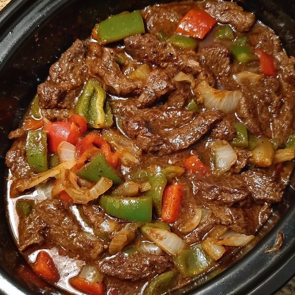 A savory crock pot pepper steak dish with peppers and beef