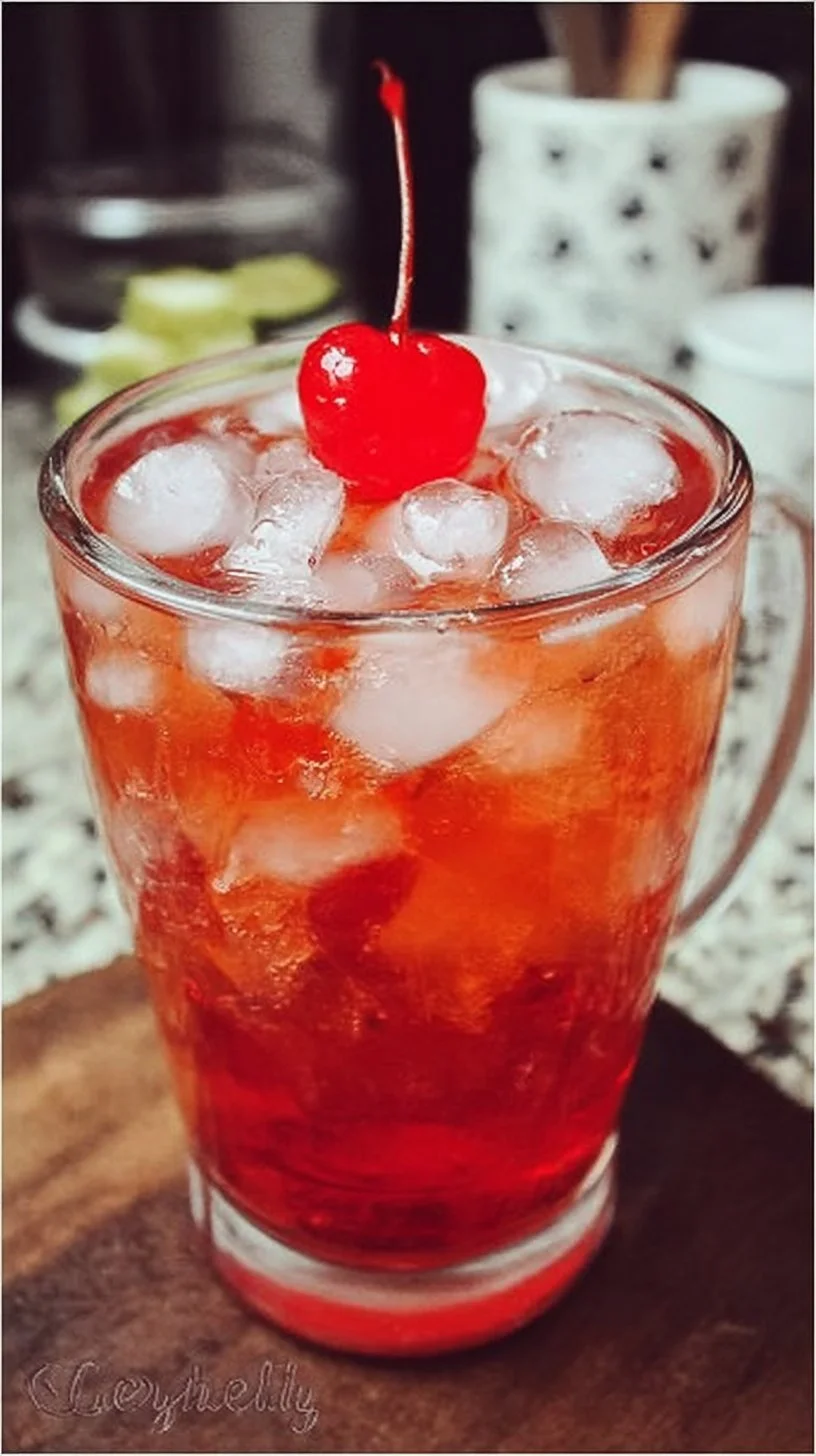 A refreshing Shirley Temple drink garnished with a cherry and orange slice.
